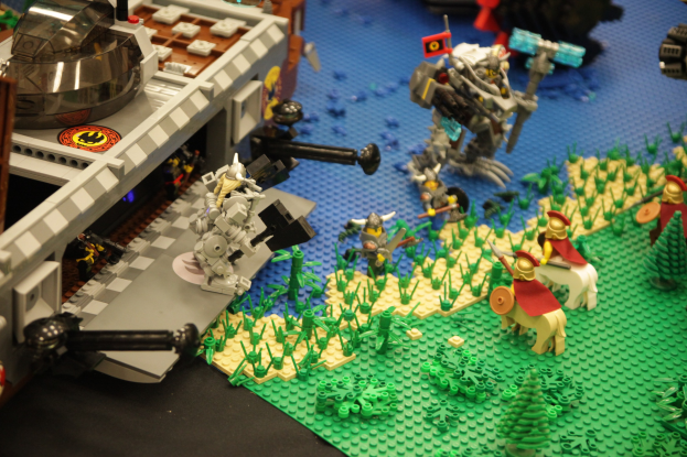 Lego-Schlossmodell mit verschiedenen Lego-Teilen, einschließlich Spielzeugen, Pflanzen und anderen Gegenständen darauf.