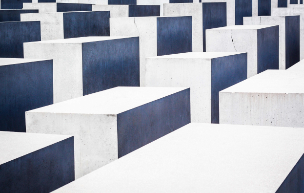Luftaufnahme des Holocaust-Mahnmals für die ermordeten Juden Europas in Berlin, die zahlreiche rechteckige Betonsteine in einem Gittermuster zeigt.