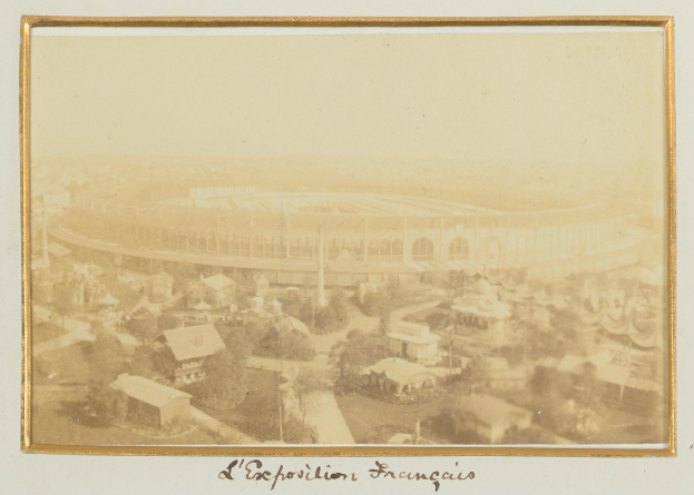Altes Schwarz-Weiß-Foto eines Stadions in einer städtischen Umgebung umgeben von Gebäuden, Bäumen und Strommasten mit Text am unteren Rand.