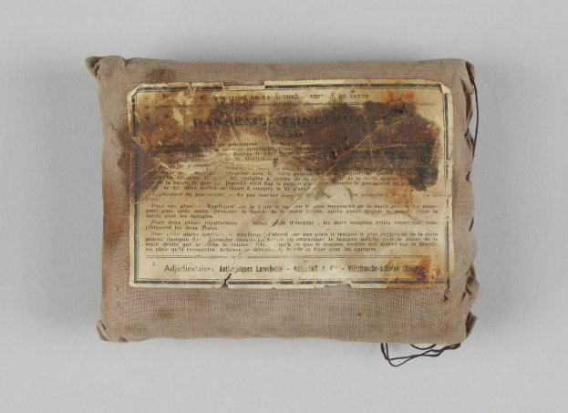 Kleiner Verbandskoffer mit einem informativen Blatt oben drauf.