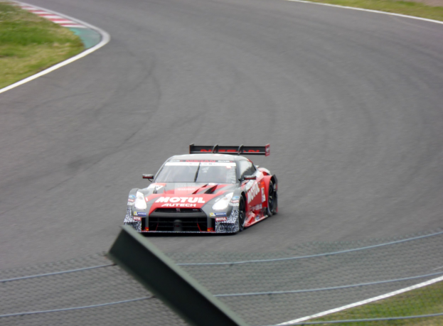 Nissan GT-R Nismo GT3 Rennauto auf der Nürburgring 24 Stunden Strecke mit grünem Gras auf beiden Seiten.