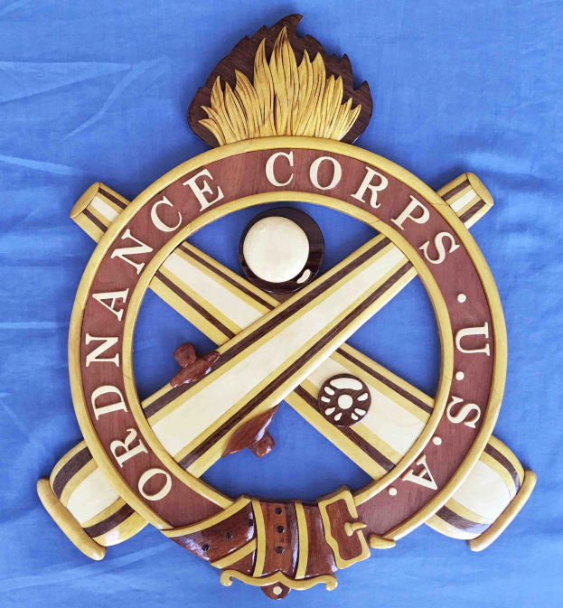 Holzschild mit "Ordnance Corps"-Text, zeigt ein geschnitztes weißes Stern auf blauem Hintergrund mit goldener Umrandung, montiert auf blauem Tuch.