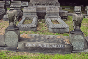 Ein Friedhof mit zahlreichen Grabsteinen, einige mit der Inschrift "John Louis Schaffer", umgeben von Gras und Bäumen.