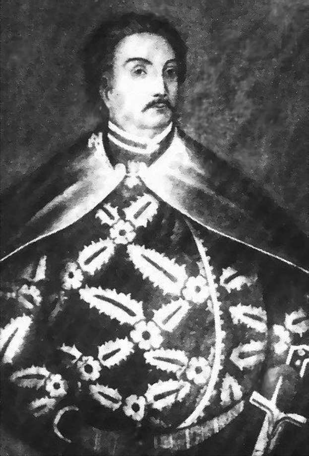 Schwarzes und weißes Foto von Papst Johannes Paul II. in Priesterrobe, der eine schwarze Robe mit weißem Kragen und Manschetten trägt und die Hände gefaltet hält, mit ernstem Gesichtsausdruck und direktem Blick.