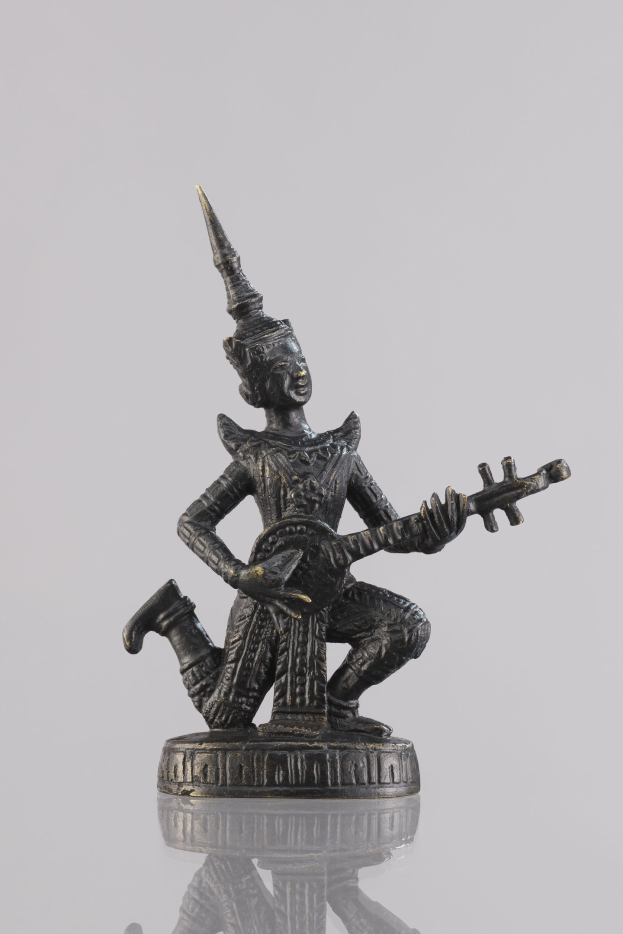 Bronzestatue eines Mannes, der eine Gitarre spielt, vor einem weißen Hintergrund.