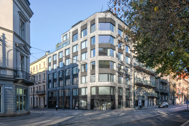 Großes modernes Bürogebäude mit zahlreichen Fenstern, umgeben von Straßeninfrastruktur, Fahrzeugen, Fußgängern, Bäumen und einem bewölkten Himmel, das als neue Hauptzentrale des Unternehmens dient.