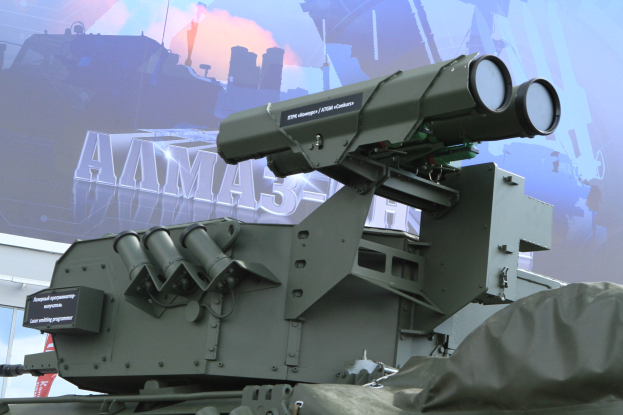 Militärfahrzeug mit einer auf einem Gebäude mit einem Banner parkenden Flugabwehrrakete.