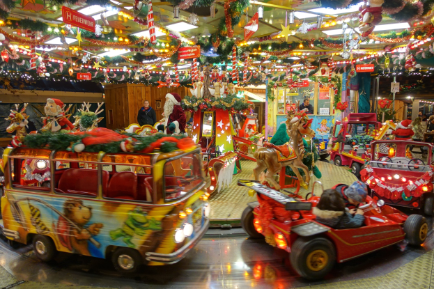 Eine Karussell-Anzeige gefüllt mit Weihnachtsdekorationen, einschließlich Spielzeug, Figuren, Lichtern und festlichen Schildern.