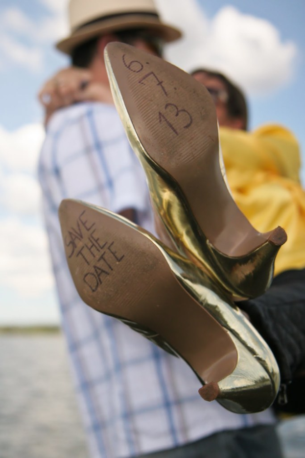 Frau in High Heels mit Datumsangaben darauf, mit einer Person, die eine andere Frau an den Händen hinter den Heels hält.