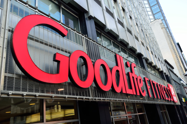 Ein Goodlife Fitness Studio in New York City mit Glaswänden und einem Namensschild, umgeben von anderen Gebäuden und einem sichtbaren Himmel im Hintergrund.