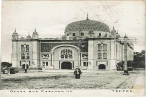 Ein altes Schwarz-Weiß-Foto der Tempelkirche in Czernowitz, Deutschland, umgeben von Menschen, Pfählen, Bäumen und Drähten.
