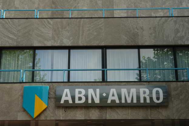 ABN AMRO-Gebäude mit einem Schild, einer Tafel, die es als Hauptsitz angibt, Geländern und Glasfenstern mit Vorhängen.